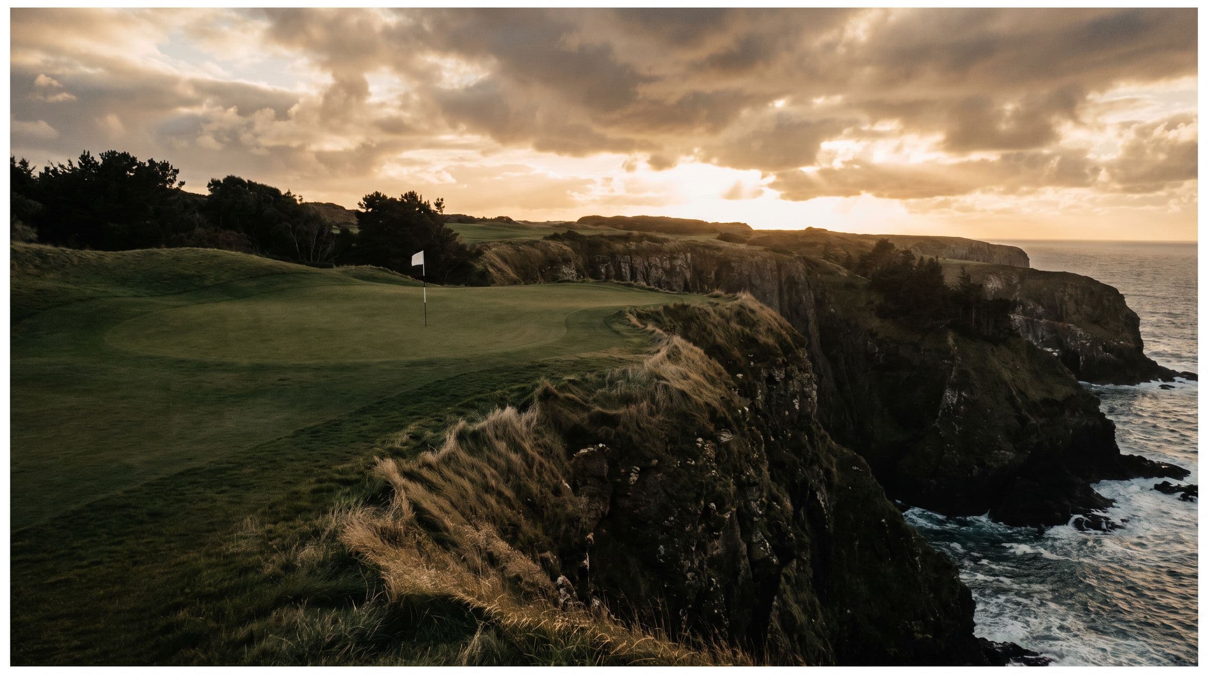 A fairway hugging a high clifftop with the ocean far below under heavy cloud.